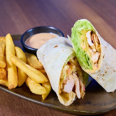 Chicken wrap with fries and dipping sauce on a plate.